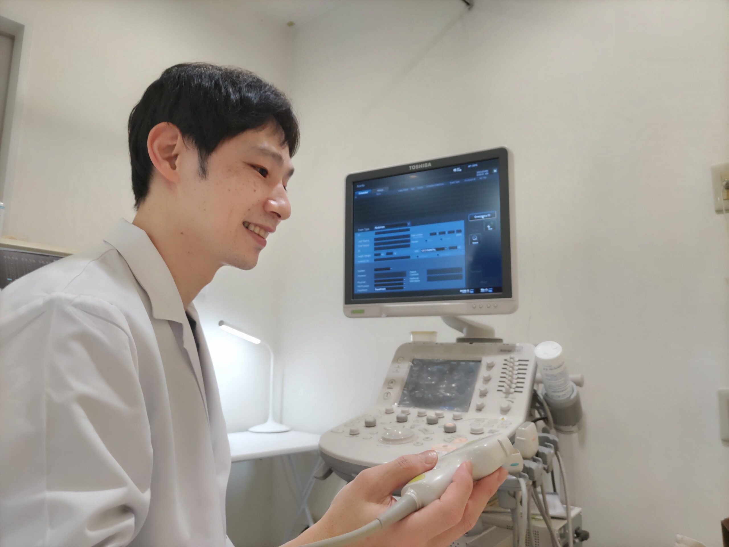 エコー検査支援を行う臨床検査技師と超音波診断装置